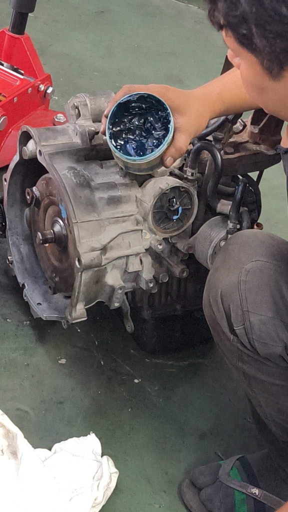 Hon Win Motor mechanic working on a gearbox removed for overhaul